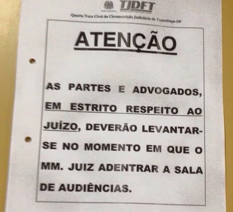FOTO: Cartaz pede a partes e advogados que se levantem para receber juiz em audiência