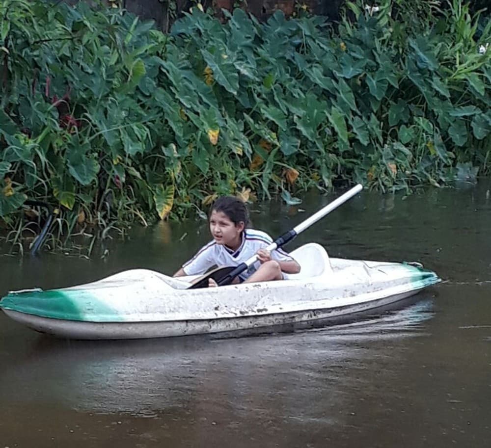 (FOTOS): Menina de 7 anos vai à escola de caiaque após temporal em SP