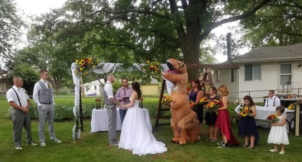 [FOTO] AINDA COM BUQUÊ: Madrinha aparece no casamento da irmã fantasiada de tiranossauro