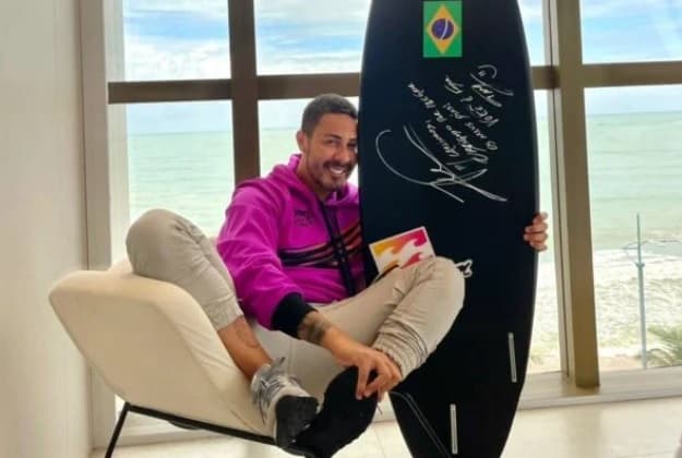 FOTO: Ítalo Ferreira dá para o comediante Carlinhos Maia prancha com que ganhou medalha de ouro olímpica