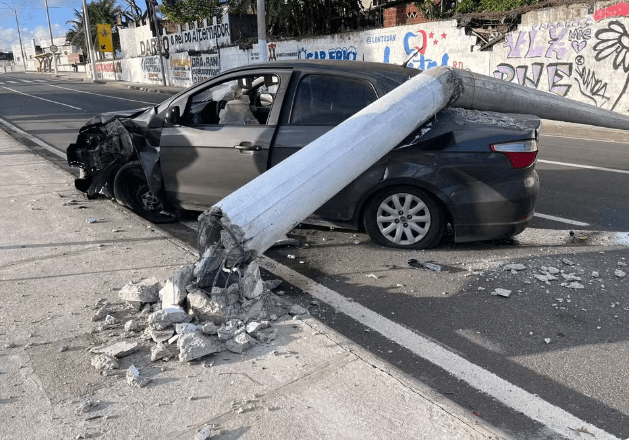 Poste cai sobre carro após colisão em Natal