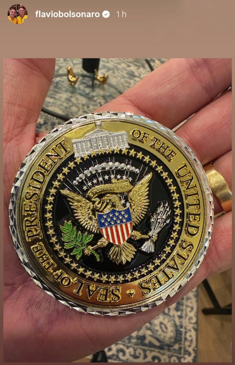 Trump entrega a Flávio Bolsonaro moeda usada para presentear aliados dos EUA
