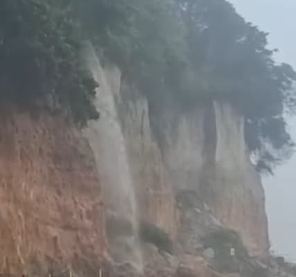 Chuva forte transforma falésia em cachoeira em Pipa; trânsito sofre alteração na praia