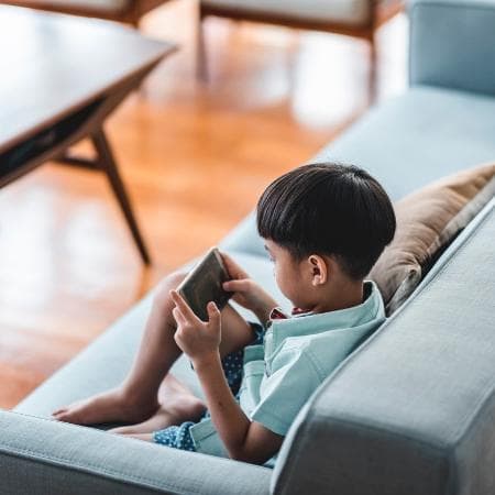 Criança enfiada no celular: a inércia é um perigo e precisa ser evitada - em tempos que a "interação familiar está sendo substituída pelas babás do mundo virtual"