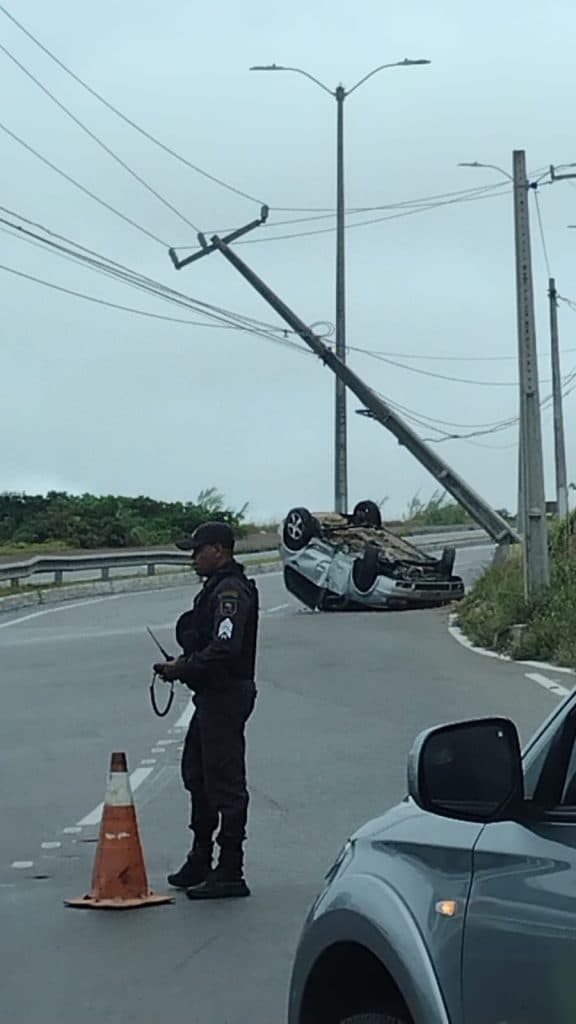 FOTO E VÍDEO: Carro capota, derruba poste e interdita trecho da Via Costeira