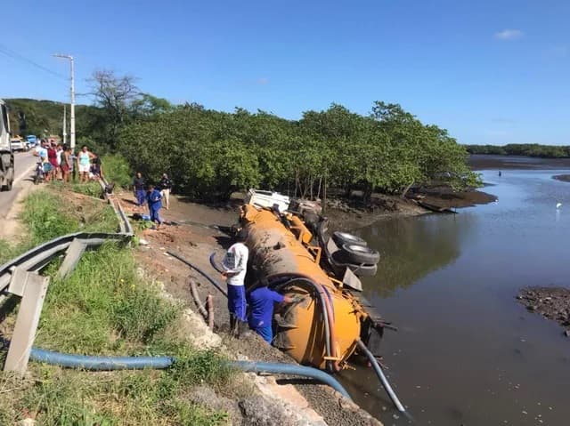 FOTOS: Caminhão limpa-fossas tomba e cai em rio de Natal