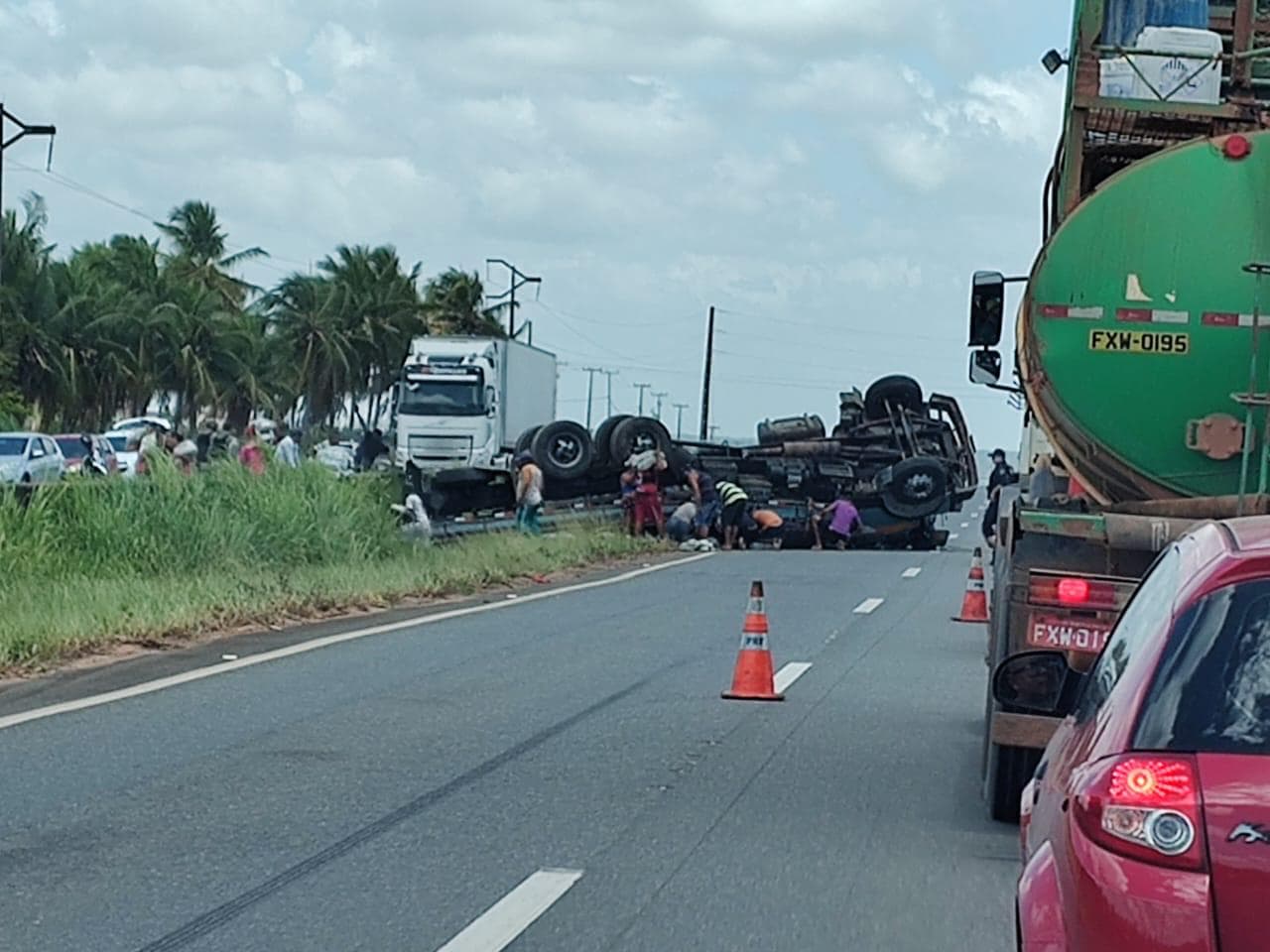 FOTOS: Carreta tomba na BR-101 e população rouba mercadorias